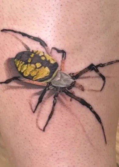 Fine-line spider tattoo with yellow detailing