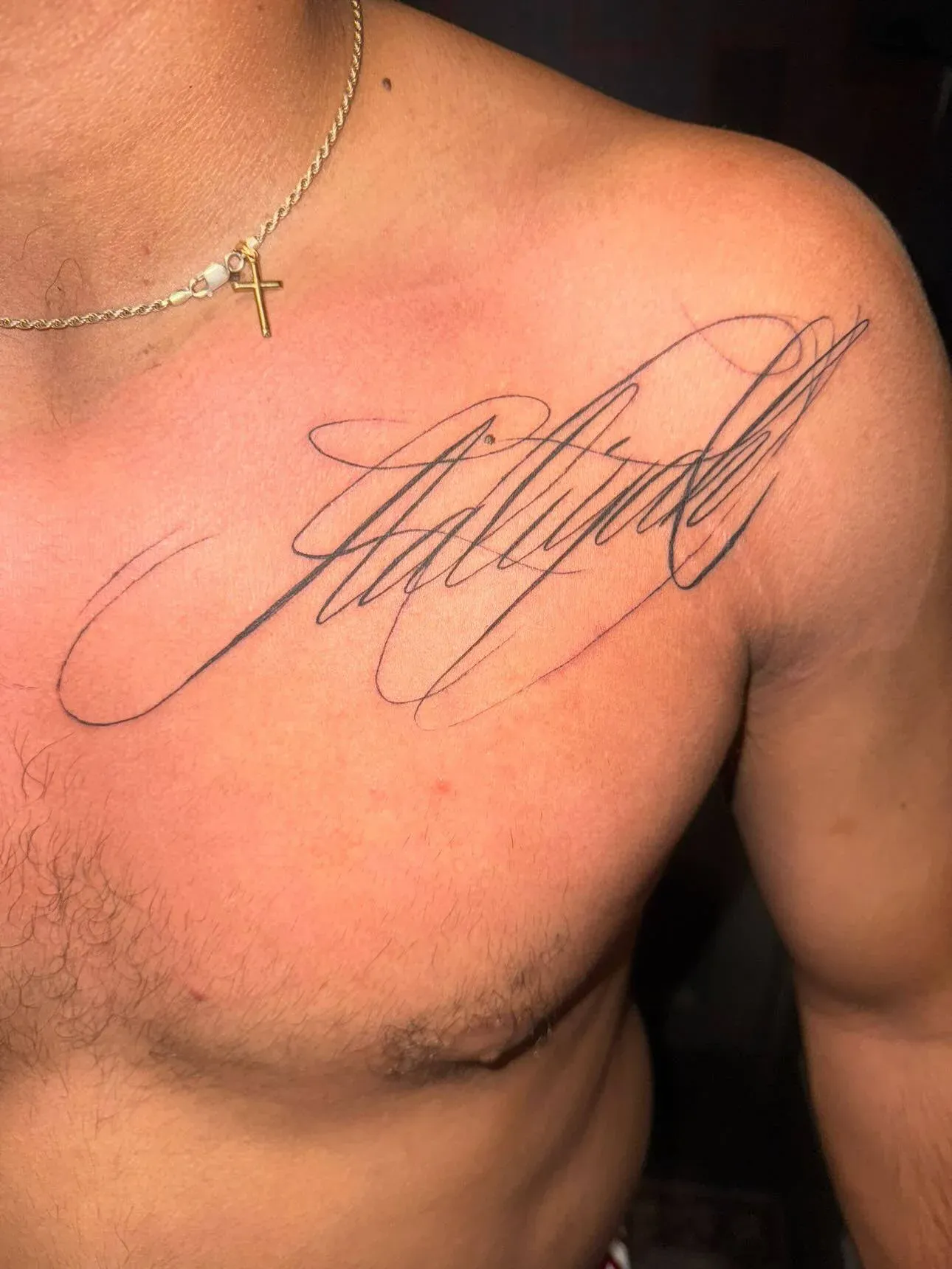 Fine-line script tattoo across the chest